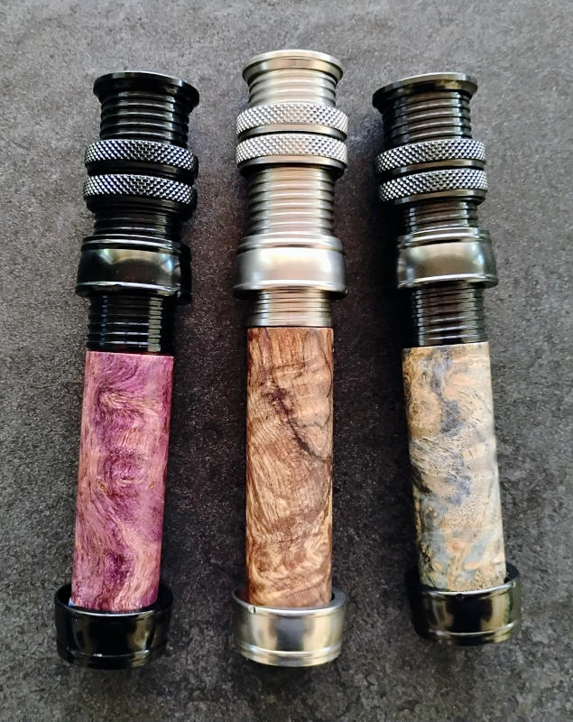 three ferguson reel seats in each of black, dark titanium, and light titanium with wood inserts